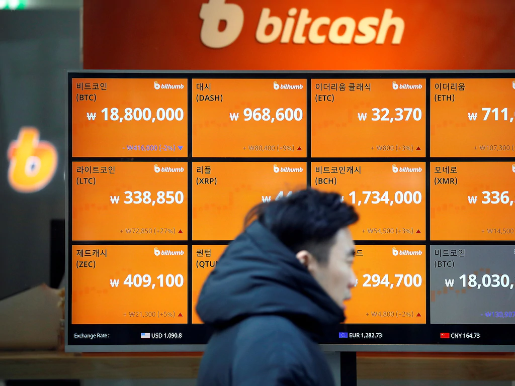 A man walks past an electric board showing exchange rates of various cryptocurrencies including Bitcoin (top L) at a cryptocurrencies exchange in Seoul, South Korea December 13, 2017.  REUTERS/Kim Hong-Ji